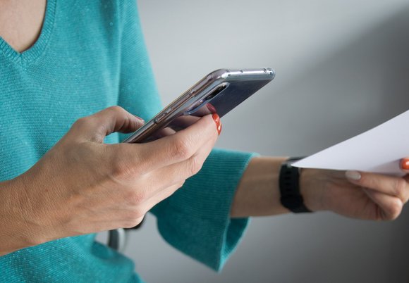 Łódź. Kobieta trzymająca telefon w ręku