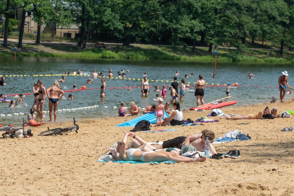 Plaża w Arturówku - ludzie kąpią się w wodzie i opalają się na piasku