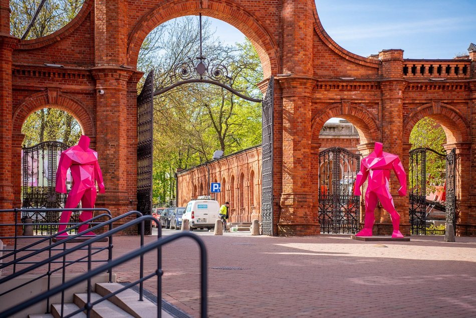 Różowe figury umiejscowione przy bramie prowadzającej do Manufaktury