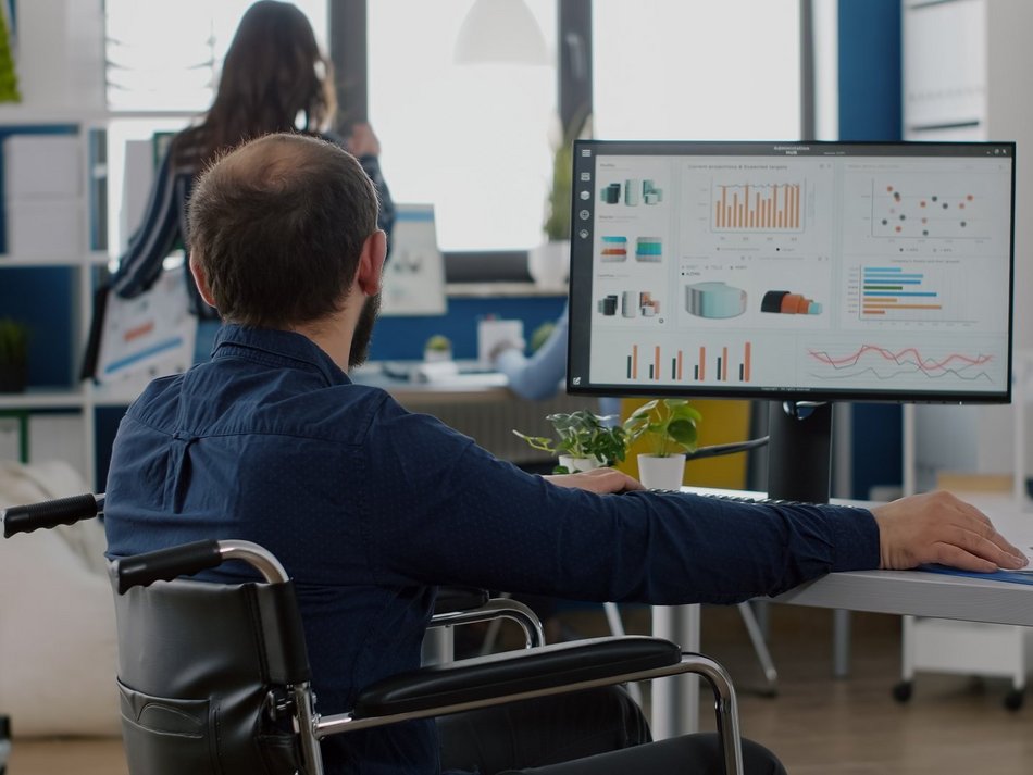Łódź. Mężczyzna na wózku przy komputerze