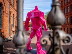 Różowe figury umiejscowione przy bramie prowadzającej do Manufaktury