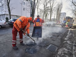 mężczyźni pracują przy łataniu drogi