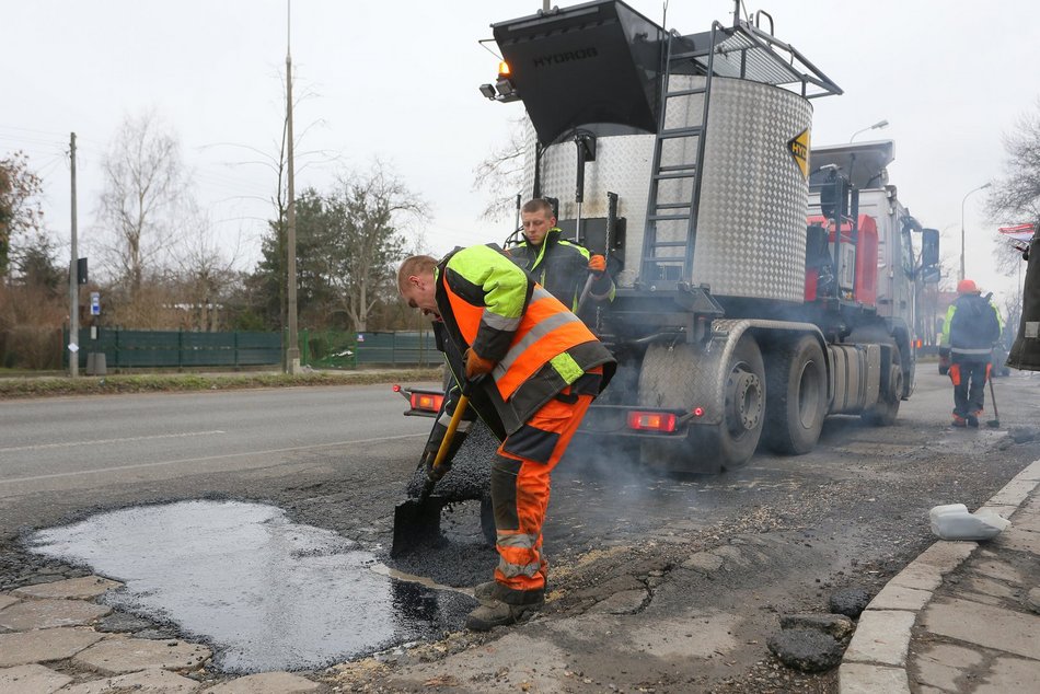 mężczyźni pracują przy łataniu drogi