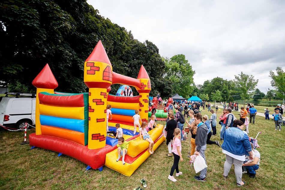 Rodzinny piknik w parku - dzieci na dmuchańcu