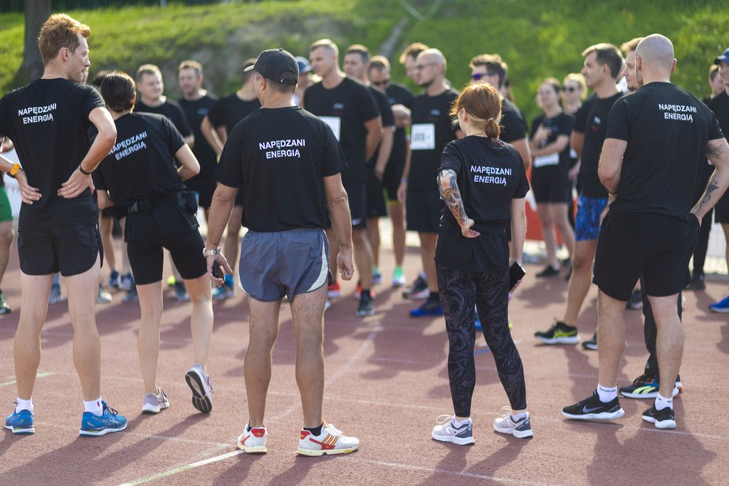 Zdjęcie przedstawia grupę ludzi w czarnych sportowych strojach, którzy przygotowują się do biegu Łódź Business Run.
