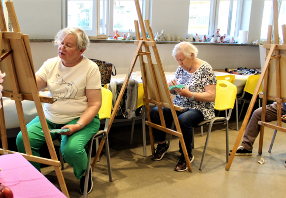 Seniorzy podczas zajęć z malowania obrazów