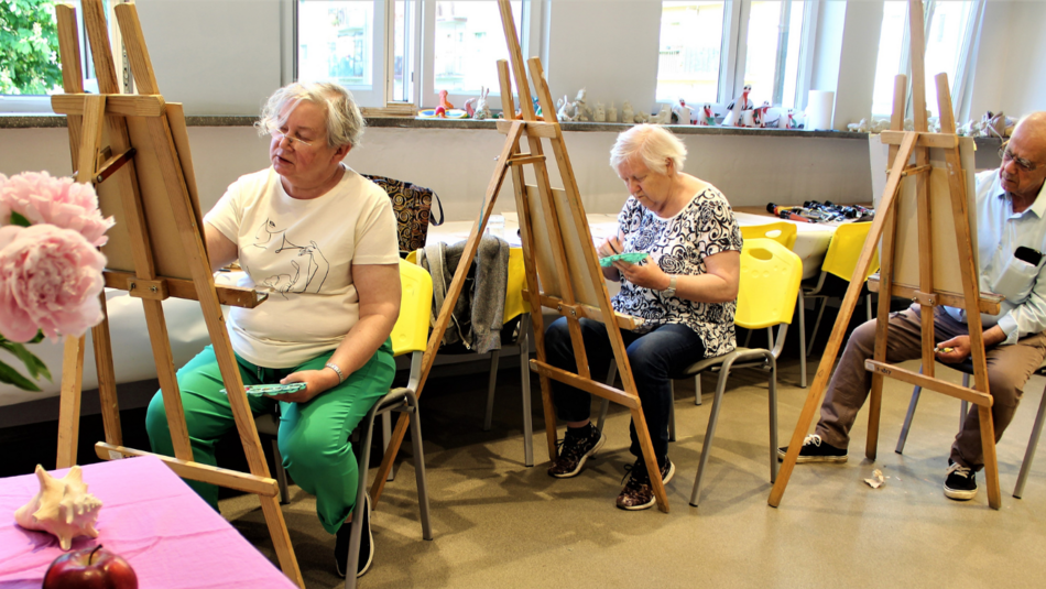 Seniorzy podczas zajęć z malowania obrazów