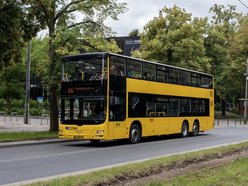 Piętrowy, żółty autobus na ulicach Łodzi