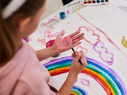 Warsztaty plastyczne dla dzieci - dziewczynka maluje tęczę