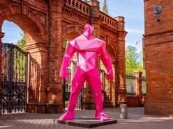 Różowe figury umiejscowione przy bramie prowadzającej do Manufaktury