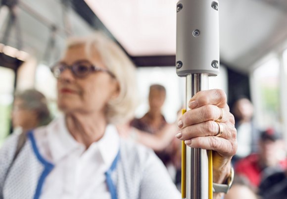 Starsza kobieta stojąca w autobusie 