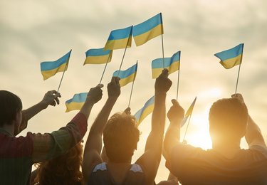 Crowd with ukrainian flags in the evening. 