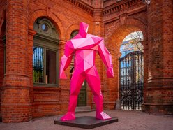 Różowe figury umiejscowione przy bramie prowadzającej do Manufaktury