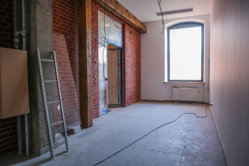 Łódź. Remont fabryki przy Sienkiewicza. Nowe wnętrza, winda, schody i brama do budynków