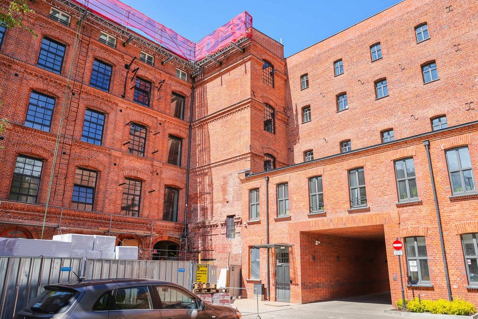 Łódź. Remont fabryki przy Sienkiewicza. Nowe wnętrza, winda, schody i brama do budynków