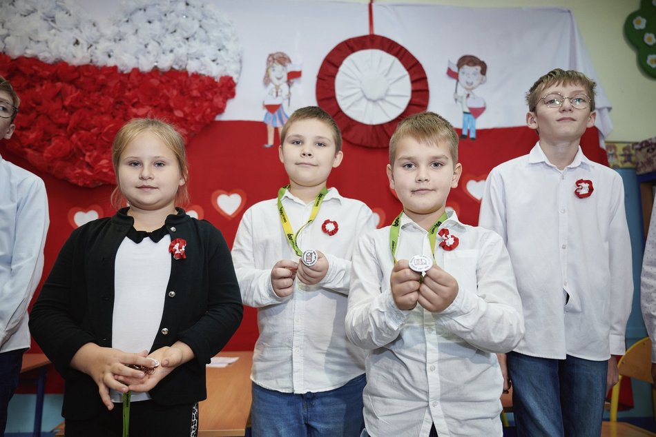 dzieci robią kokardy patriotyczne