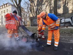 mężczyźni pracują przy łataniu drogi