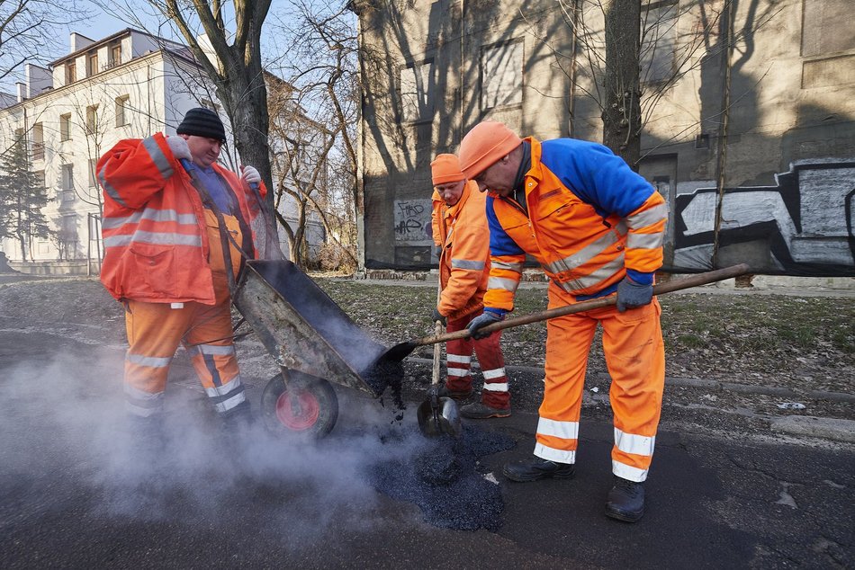 mężczyźni pracują przy łataniu drogi