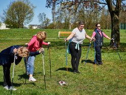 seniorzy ćwiczą z kijkami nordic walking