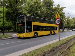 Piętrowy, żółty autobus na ulicach Łodzi