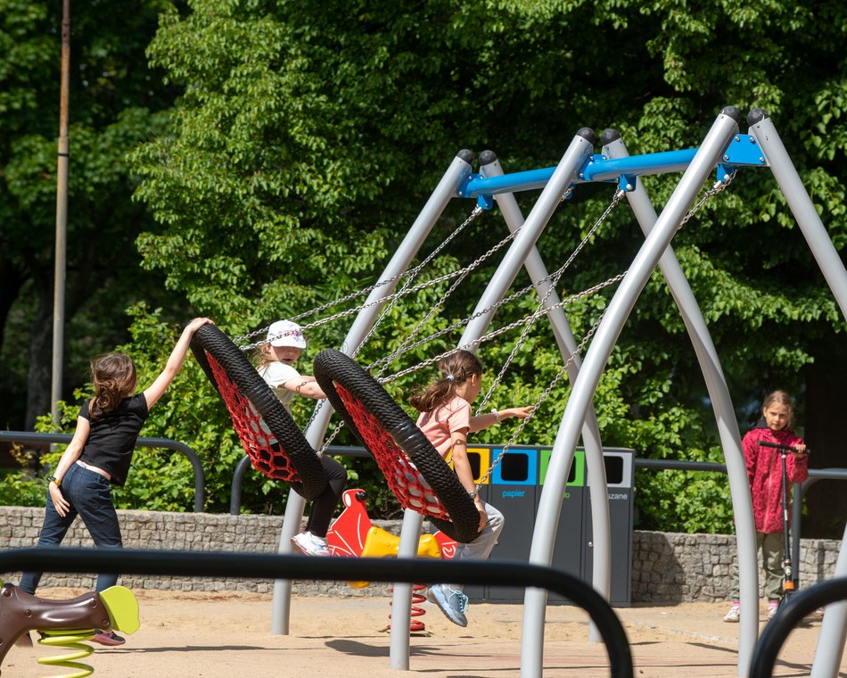 Plac zabaw w parku Podolskim w Łodzi - dzieci na huśtawkach