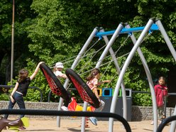 Plac zabaw w parku Podolskim w Łodzi - dzieci na huśtawkach
